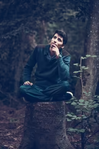Zamyšlený muž sedící v zeleni
